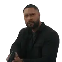 a man with a beard is holding a gun in his hands