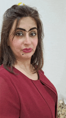 a woman is wearing a red shirt and making a face