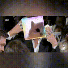 a man is holding a picture of a dog on his face