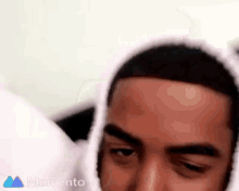 a close up of a man 's face with a hoodie on .
