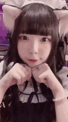 a girl wearing a cat ear headband is making a face .
