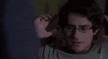 a man is pointing a gun at the camera in a dark room .