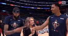 a basketball player wearing a i botta jersey talks to a woman
