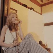 a woman is talking on a telephone while sitting on a chair