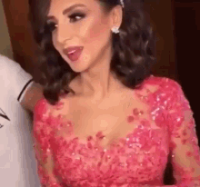 a woman in a pink dress is standing next to a man .