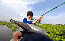 a man is riding a jet ski through a field of green plants