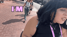 a woman walking down a brick sidewalk with the word i 'm above her head