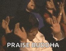 a group of people are raising their hands in the air with the words praise buddha below them