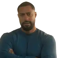 a man with a beard is wearing a blue shirt and has his arms crossed