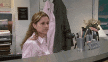 a woman sits at a reception desk with a sign that says reception