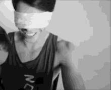 a black and white photo of a man with a blindfold on his eyes .