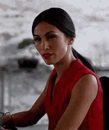 a woman in a red dress is sitting at a desk with a laptop .