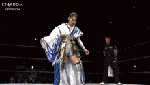 a woman in a blue and white kimono with the word stardom on the bottom right