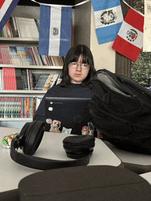 a girl sits at a desk with an hp laptop on her lap