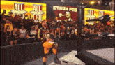 a wrestler holding a championship stands in front of a screen that says ethan pag