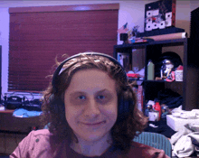 a woman wearing headphones is smiling in front of a shelf with a mug that says ' i love you '