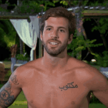 a shirtless man has a tattoo on his chest that says ' مكتب '