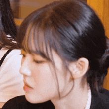 a close up of a woman 's face with a bun on her hair