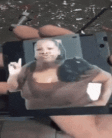 a person is holding a picture of a woman giving a peace sign