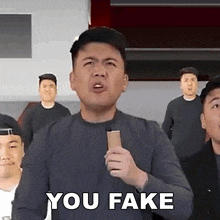 a group of men are standing around a man holding a microphone and saying you fake