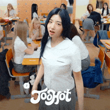 a girl with blue hair is standing in a classroom with the word joohot on the bottom right