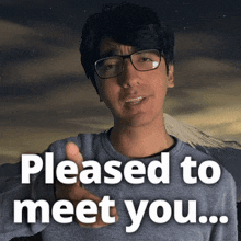 a man with glasses says pleased to meet you with a mountain in the background