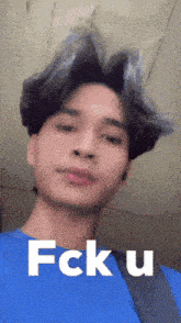 a man in a blue shirt says fck u in white letters