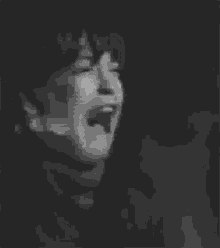 a black and white photo of a young boy crying .