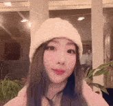 a woman wearing a white knitted hat with the letter s on it