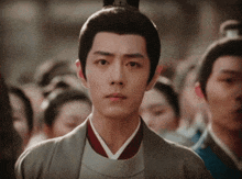 a man with a ponytail is standing in a crowd of people