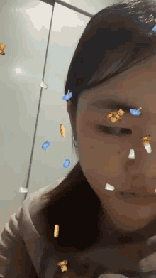 a close up of a woman 's face with a bunch of stickers on it
