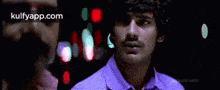 two men are standing next to each other in a dark room .
