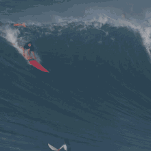 surfer red bull taking a wave surfing on a wave surfing