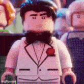 a lego man in a tuxedo and bow tie is standing in a crowd .