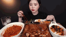 a woman is sitting at a table eating a variety of food