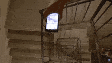 a person holding a cell phone on a staircase with a r on the bottom right