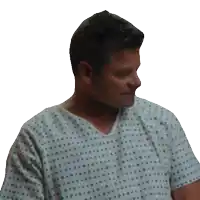 a man wearing a hospital gown with blue dots on it