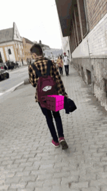 a person walking down a sidewalk with a pink box