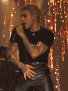a man is singing into a microphone with the name joiif.521 on the bottom