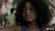 a girl with curly hair and a netflix logo in the corner