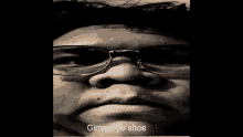 a close up of a person 's face with glasses and the words gimme yo shoe below it