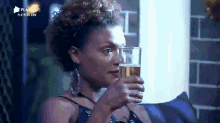 a woman is sitting on a couch holding a glass of beer in her hand .