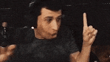 a man wearing headphones is making a funny face while sitting in front of a microphone .