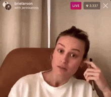 a woman is sitting in a chair with a live button above her head