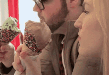 a man and woman eating ice cream cones with sprinkles