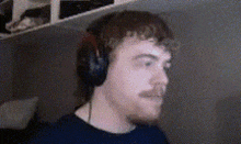 a man with a mustache wearing headphones and a black shirt