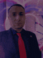 a man in a suit and tie with a pin on his jacket