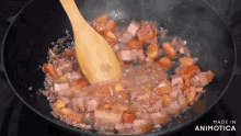 a wooden spoon is stirring food in a pan that says made in animatica on the bottom
