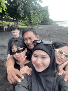 a group of people are posing for a picture on a beach