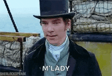 a man wearing a top hat and a suit is standing on a boat in the ocean .